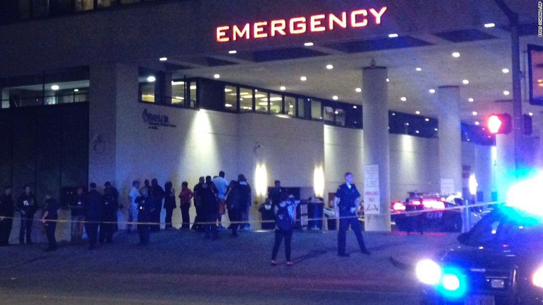 Police and others gather at the emergency entrance to the Baylor University Medical Center.