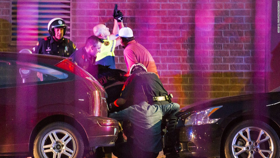 Police officers shield bystanders after shots were fired at the protest.