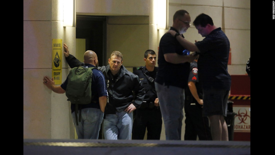 Law enforcement officials wait outside the emergency room entrance of the Baylor University Medical Center.