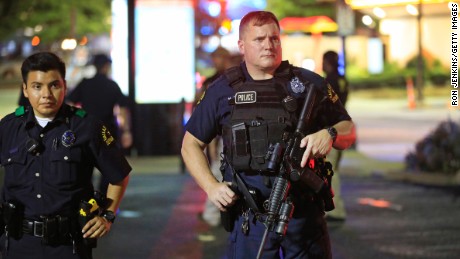 Dallas police stand near the scene where four Dallas police officers were shot and killed on July 7.