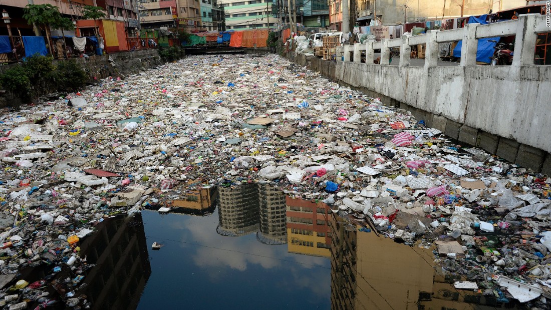 Buildings are reflected in the waters of a garbage filled river in Manila.