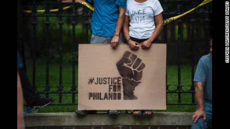 ST. PAUL, MN - JULY 07: A couple hold a sign protesting the killing of Philando Castile outside the Governor&#39;s Mansion on July 7, 2016 in St. Paul, Minnesota. Castile was shot and killed the previous night by a police officer in Falcon Heights, MN. (Photo by Stephen Maturen/Getty Images)