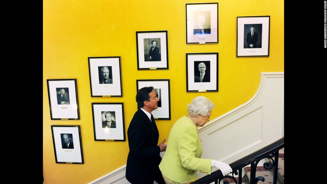 Queen Elizabeth II walks up the staircase in 10 Downing Street with Cameron in 2011.