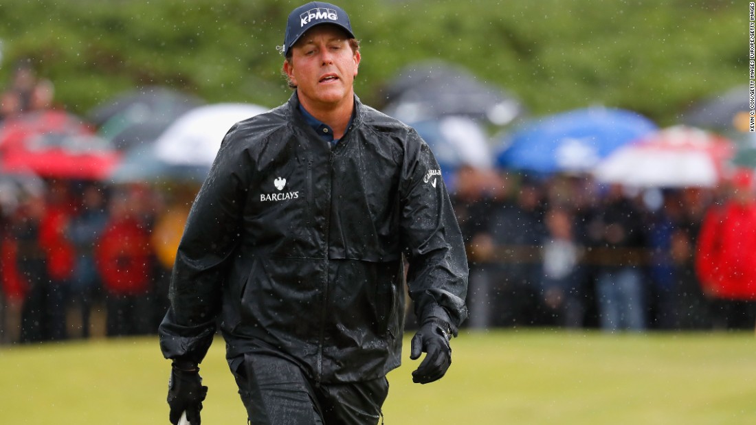 First-round leader Phil Mickelson set off in the dry but was engulfed in a deluge on the back nine.  