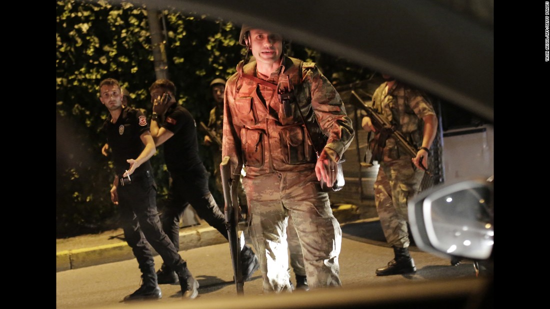 Turkish security officers detain police officers, seen in black, in Istanbul, during a security shutdown on the Bosphorus Bridge.