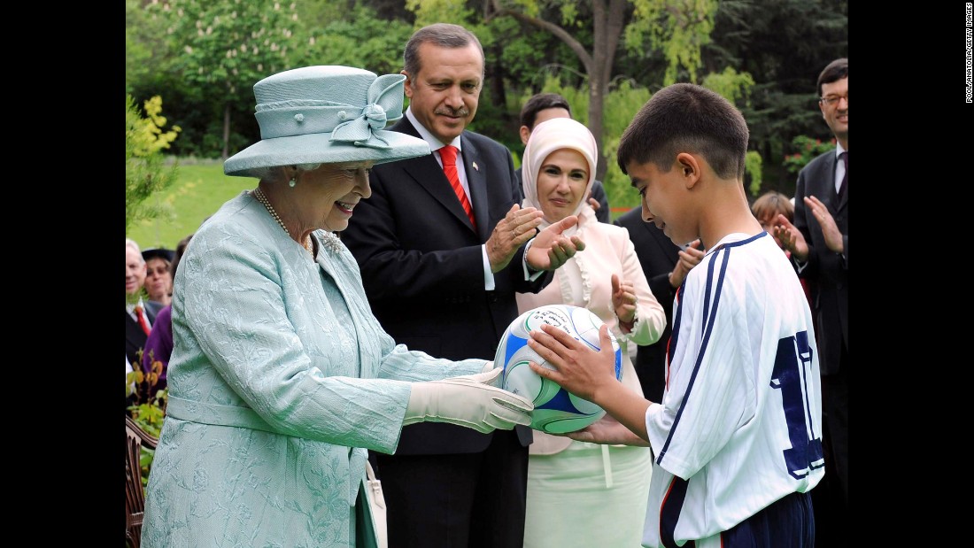 Britain&#39;s Queen Elizabeth II, accompanied by Erdogan and his wife Emine Erdogan, gives a David Beckham signed soccer ball to a Turkish boy during at a garden party held for her birthday at the British Embassy in Ankara, Turkey, on May 16, 2008. It was the Queen&#39;s first visit to Turkey in 37 years.
