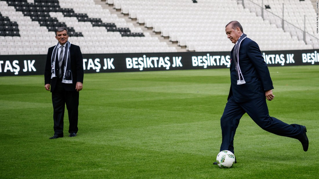 Erdogan, right, kicks a soccer ball while Former Turkish President Abdullah Gul watches at Besiktas soccer club&#39;s new Vodafone Arena on its opening day in Istanbul on Sunday, April 10.