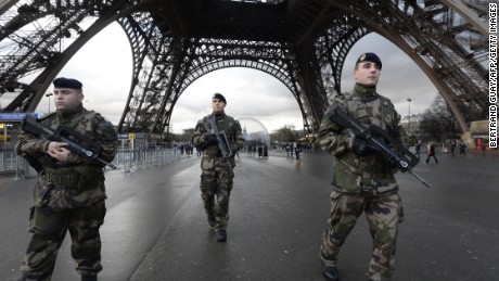 French soldiers patrol in front of the Eiffel Tower on January 8, 2015 in Paris as the capital was placed under the highest alert status a day after heavily armed gunmen shouting Islamist slogans stormed French satirical newspaper Charlie Hebdo and shot dead at least 12 people in the deadliest attack in France in four decades. A  huge manhunt for two brothers suspected of massacring 12 people in an Islamist attack at a satirical French weekly zeroed in on a northern town Thursday after the discovery of one of the getaway cars. As thousands of police tightened their net, the country marked a rare national day of mourning for Wednesday&#39;s bloodbath at Charlie Hebdo magazine in Paris, the worst terrorist attack in France for half a century. AFP PHOTO / BERTRAND GUAY        (Photo credit should read BERTRAND GUAY/AFP/Getty Images)