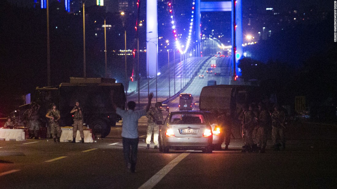 A man approaches Turkish military with his hands up at the entrance to the partially closed Bosphorus Bridge in Istanbul.