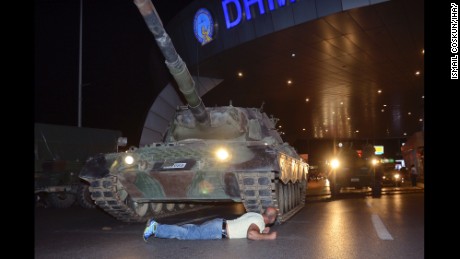 A man lays in front of a tank in the entrance to Istanbul's Ataturk airport, early Saturday, July 16, 2016. Members of Turkey's armed forces said they had taken control of the country, but Turkish officials said the coup attempt had been repelled early Saturday morning in a night of violence, according to state-run media. (Ismail Coskun/IHA via AP)