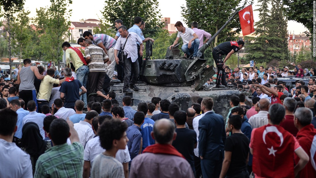 People gather on top of a Turkish military tank in Ankara in the morning after the coup attempt. National intelligence officials said the coup was put down and that the government remains in control. 