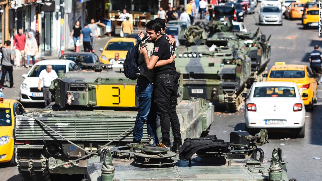 A Turkish police officer in Istanbul embraces a man on a tank in the wake of the violence overnight.