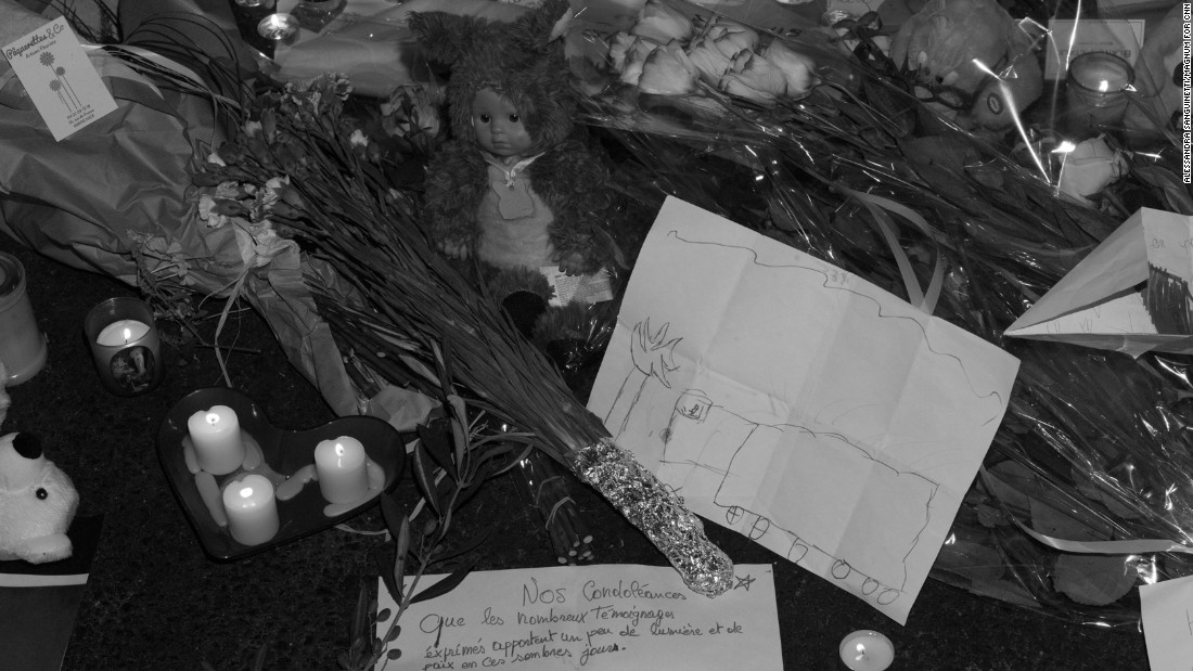 People left candles and messages at a memorial site. On one of the pieces of paper, a child drew a truck.