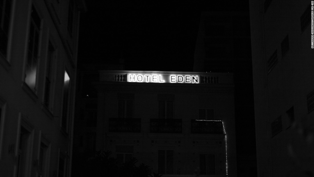 A hotel sign is lit up in the night.