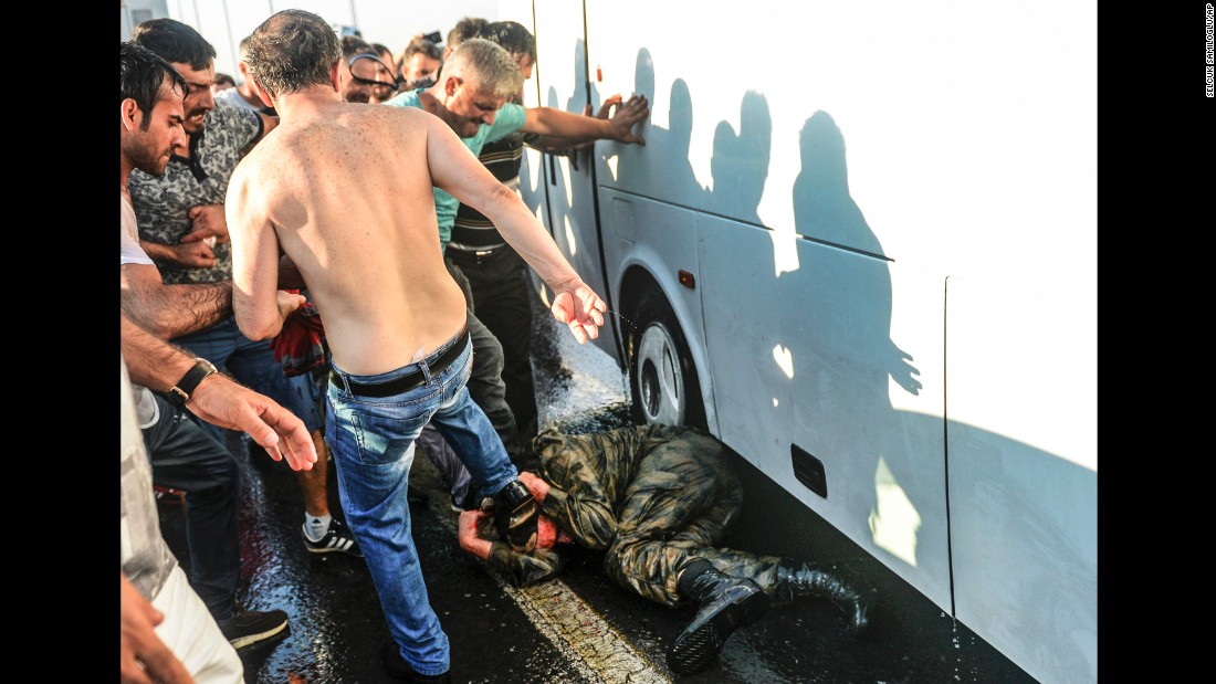 People kick and beat a Turkish soldier suspected in the attempted coup on Istanbul&#39;s Bosphorus Bridge on July 16.