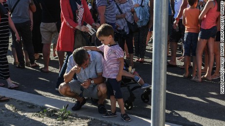  A young boy comforts his father Saturday on the Promenade des Anglais in Nice. 