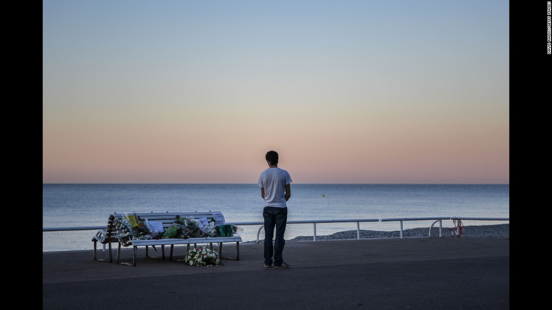 A man takes in a tribute to the Nice victims left on a bench near the site of the attack on the Promenade des Anglais on July 17.