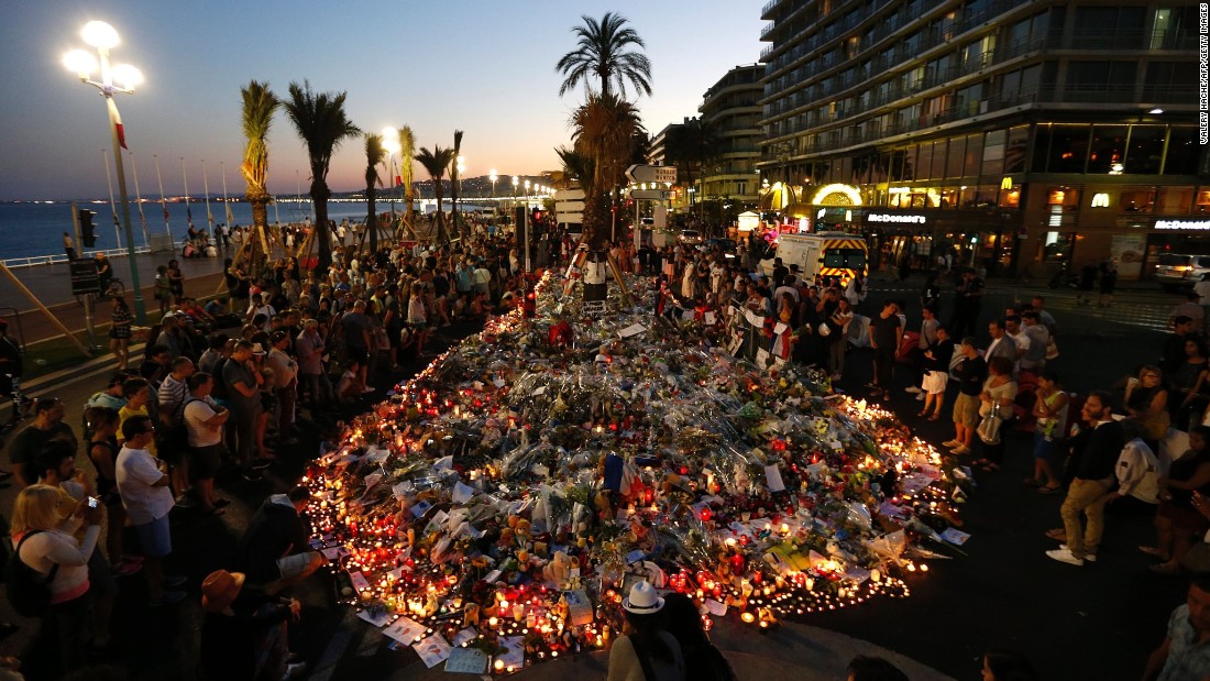 People gather at a makeshift memorial on the Promenade des Anglais in Nice on Sunday, July 17. ISIS has claimed responsibility for the truck rampage, but the French interior minister said that any link between the attacker -- Mohamed Lahouaiej-Bouhlel -- and the terror group has yet to be established.