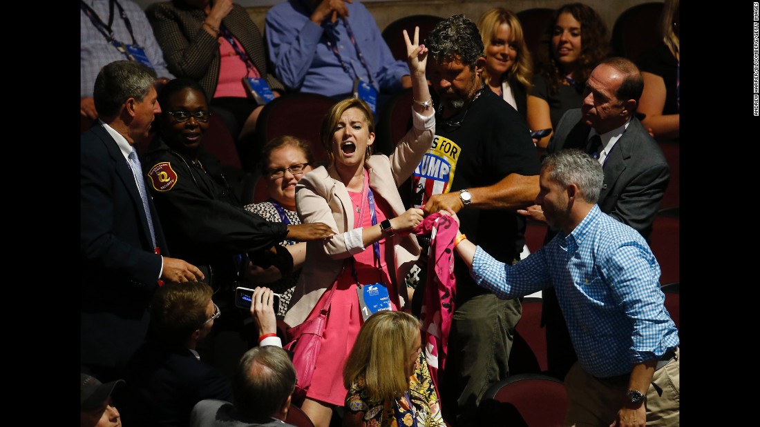 A protester flashes a peace sign on the floor of the convention on Monday.