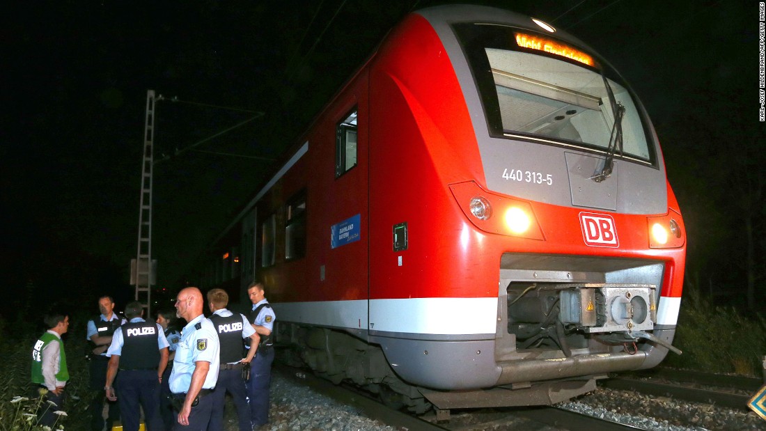 Police stand by a regional train in Wurzburg, Germany, on Monday, July 18, after authorities said a man attacked passengers with an ax. German police shot the man dead in a confrontation after he fled the train. Four passengers who were attacked are in serious condition, police said.