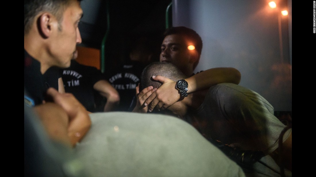 Turkish police officers cover the eyes of soldiers as they are transported in a bus from the courthouse in Istanbul on July 16.