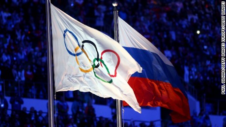 The Olympic flag and Russian flag are raised as the Russian National Anthem is sung during the 2014 Sochi Winter Olympics Closing Ceremony.