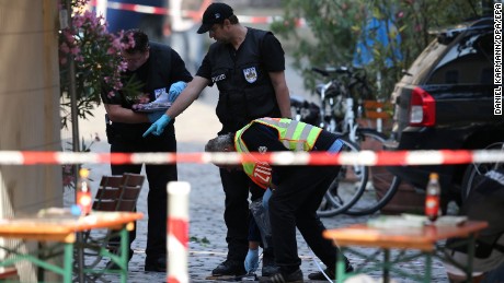 Police officers conduct an investigation on Monday, following a suicide bombing in Ansbach, Germany.