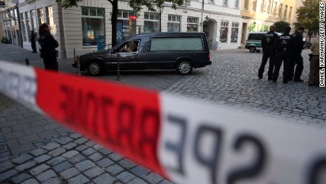 Police watch a hearse leave the scene of a suicide attack in the southern German city of Ansbach on 25 June, 2016 
A Syrian migrant set off an explosion at a bar in southern Germany that killed himself and wounded a dozen others late Sunday, authorities said, the third attack to hit Bavaria in a week.
The 27-year-old, who had spent a stint in a psychiatric facility, had intended to target a music festival in the city of Ansbach but was turned away because he did not have a ticket.
 / AFP / dpa AND DPA / Daniel Karmann / Germany OUT        (Photo credit should read DANIEL KARMANN/AFP/Getty Images)