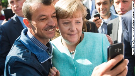 An asylum seeker takes a selfie with German Chancellor Angela Merkel during the leader&#39;s visit to refugee registration centre in Berlin on September 10, 2015.