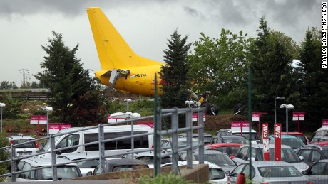 The DHL courier company&#39;s Boeing 737-400 cargo aircraft rests on a road after it came off the runway during landing at airport of Bergamo Orio al Serio, Italy, on Friday, August 5.