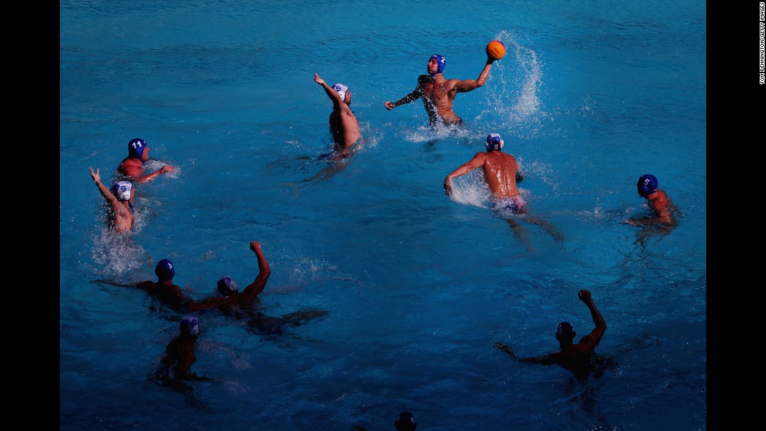 Hungary&#39;s Gergo Zalanki, top right, passes the ball against Serbia&#39;s Milos Cuk, top left, during the men&#39;s water polo preliminary round match between their two countries.