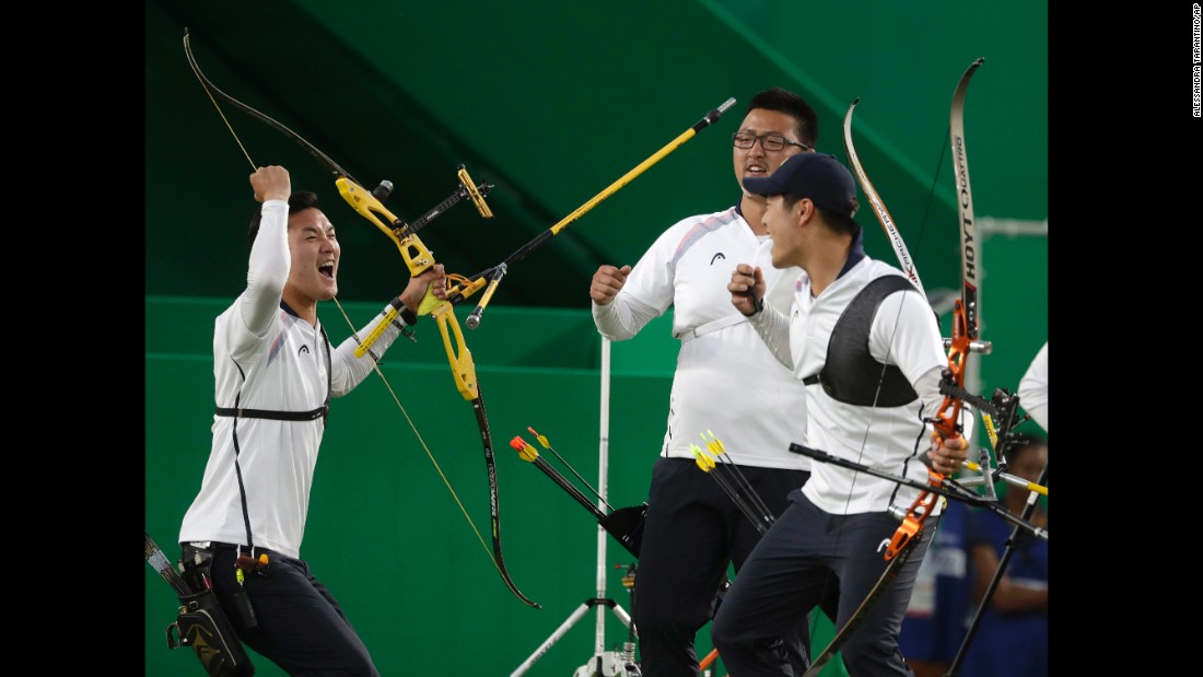 South Korea&#39;s Ku Bon-chan, Kim Woo-jin and Lee Seung-yun celebrate after winning the men&#39;s team archery gold medal match at the Sambadrome venue.