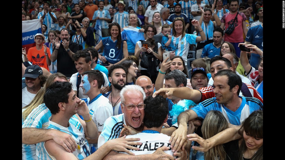 Volleyball player Demian Gonzalez is embraced by Argentina fans after his team beat Russia in a preliminary round. They will next face Poland on Thursday.