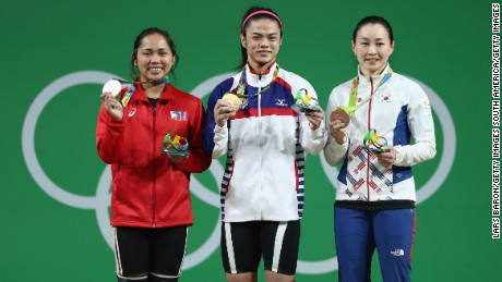 Hsu Shu-ching (middle) holds her gold medal alongside silver medalist Hidilyn Diaz of the Philippines and bronze medalist Jin Hee Yoon of South Korea.