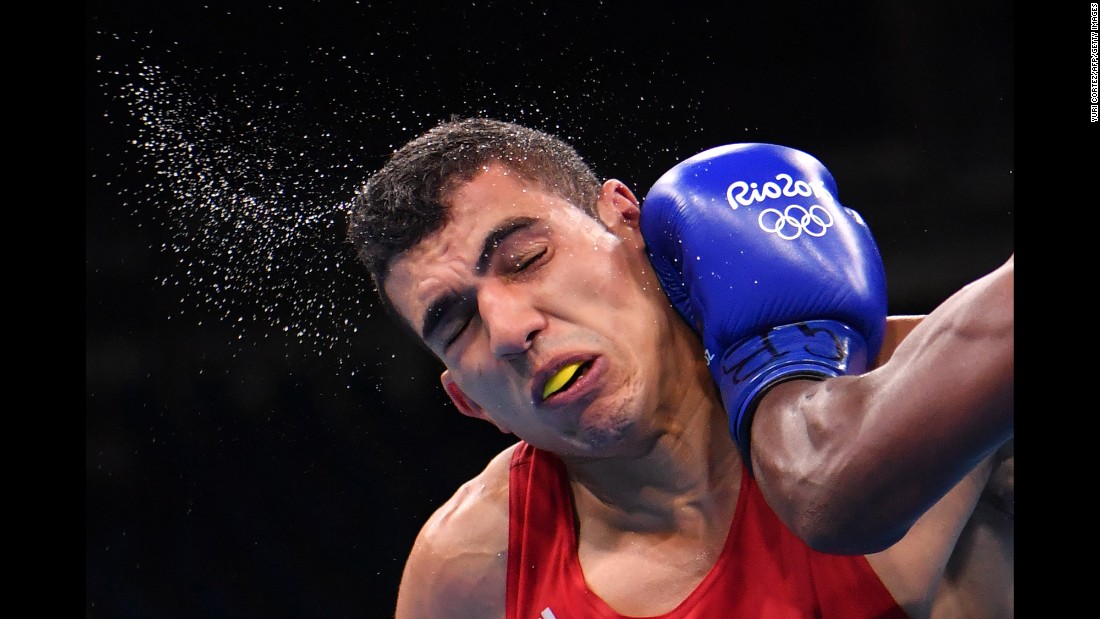 Morocco&#39;s Mohammed Rabii is punched by Kenya&#39;s Rayton Okwiri during their welterweight bout. Rabii advanced to the quarterfinals.
