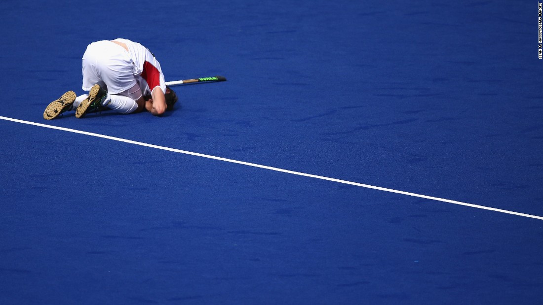 Belgian field hockey player Felix Denayer lies injured on the turf during a match against Spain.