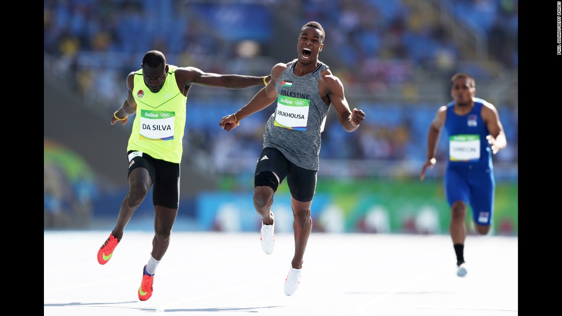 Mohammed Abukhousa of Palestine, center, and Holder da Silva of Guinea-Bissau compete in the men&#39;s 100-meter preliminary round. Abukhousa was later carried off the field after an injury.