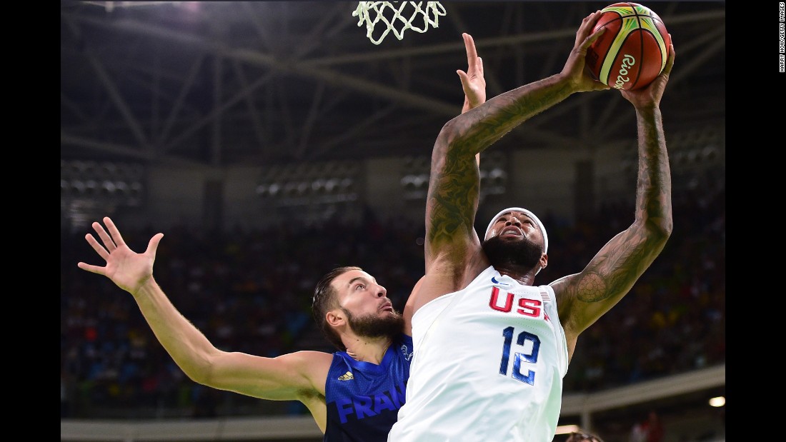 Demarcus Cousins, right, shoots against Joffrey Lauvergne of France during a men&#39;s preliminary round Group A basketball game, which the US won 100-97.