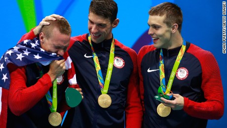 Members of the men&#39;s 4 x 100m Freestyle Relay team, including Michael Phelps, with their medal-holders. 