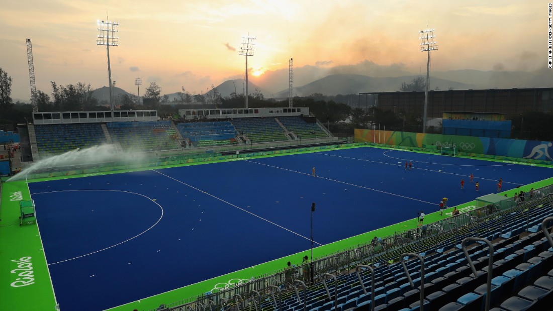 A wildfire burns in hills near the field hockey venue before a quarterfinal match between Great Britain and Spain.