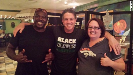 Restaurant owner Rick Camuglia, center, sports a &quot;black olives matter&quot; T-shirt in a photo with two customers.