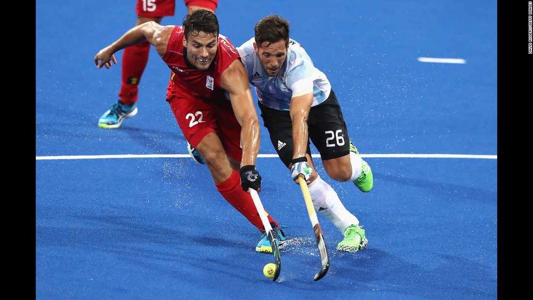 Belgium&#39;s Simon Gougnard, left, is challenged by Argentina&#39;s Agustin Mazzilli during the field hockey final. Argentina won the gold medal with a 4-2 victory.
