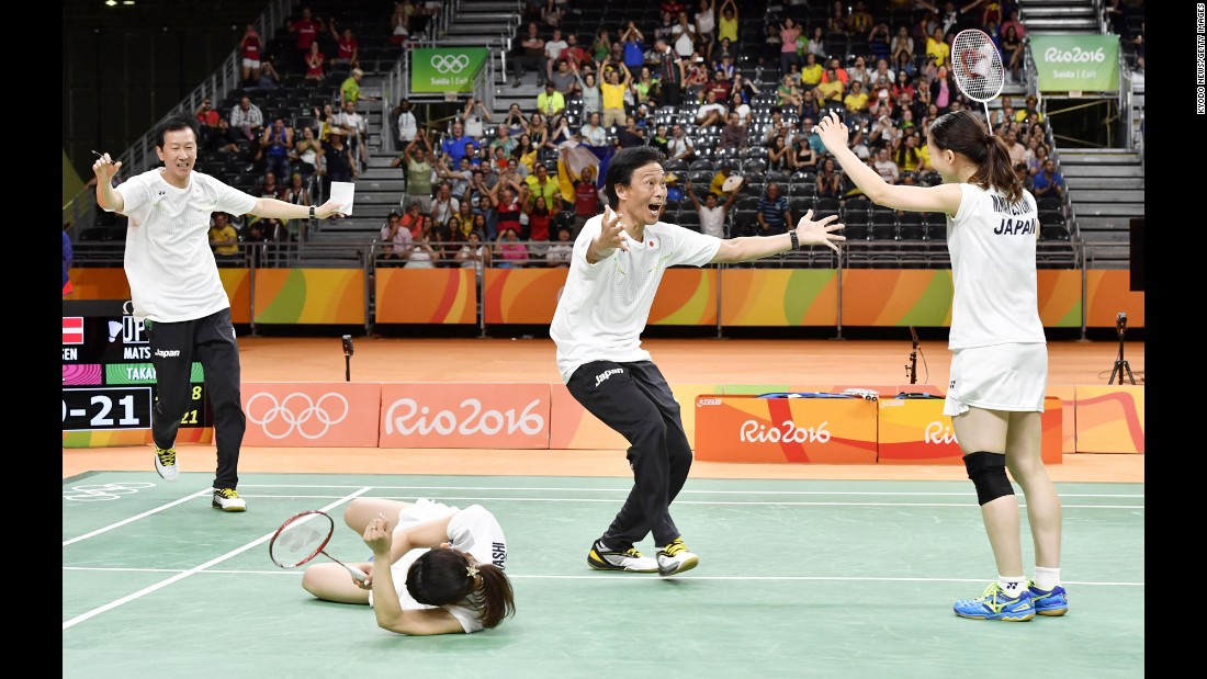 Japan&#39;s Misaki Matsutomo, right, and Ayaka Takahashi, second from left, celebrate with their coaches after winning the doubles final in badminton.