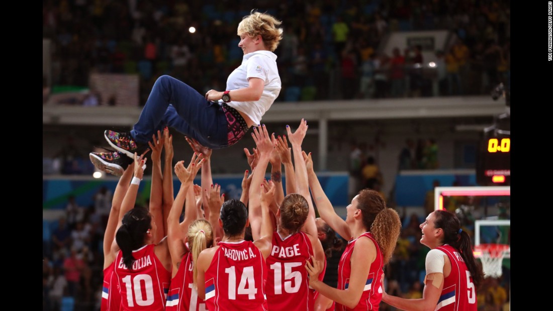 The Serbian basketball team celebrates with their coach, Marina Maljkovic, after defeating France 70-63 in the bronze medal match.