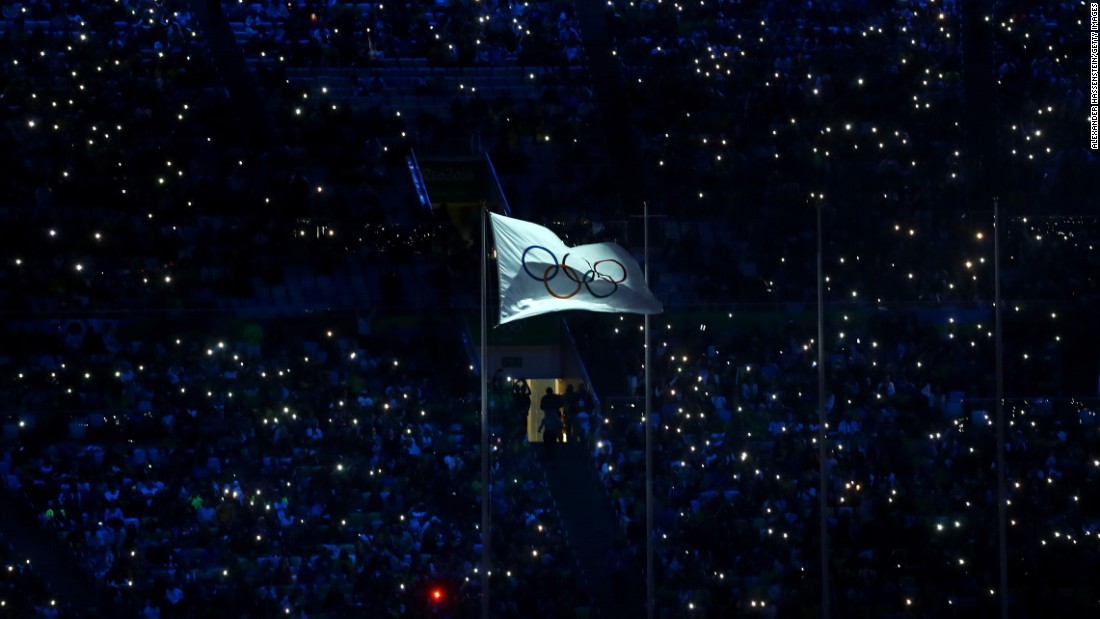 The International Olympic Committee flag waves in the stadium.