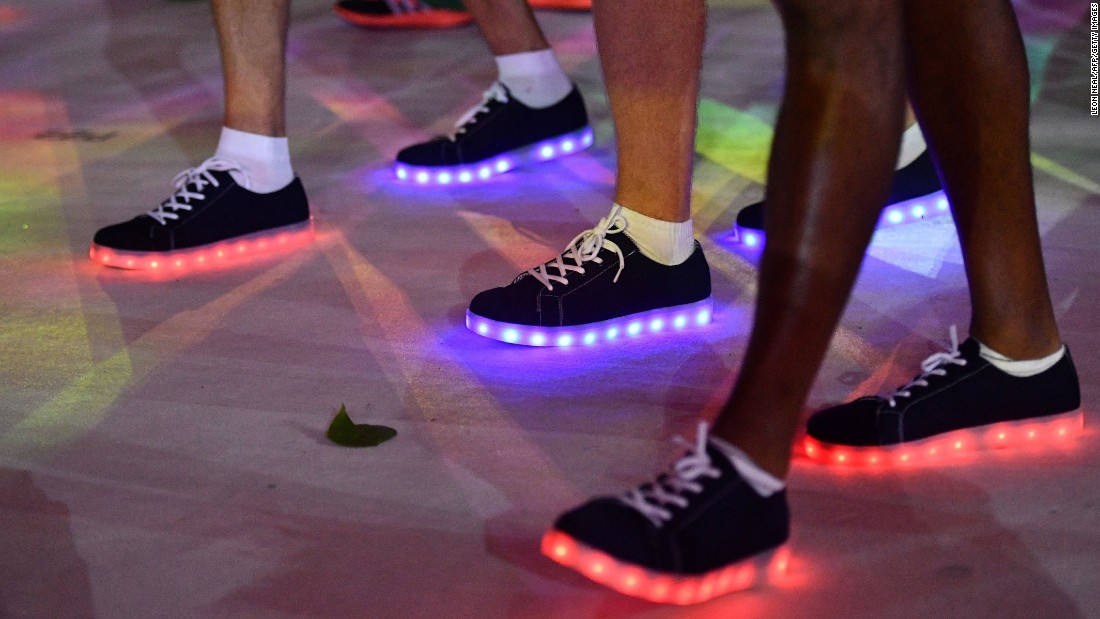 Athletes wearing illuminated shoes march during the closing ceremony.