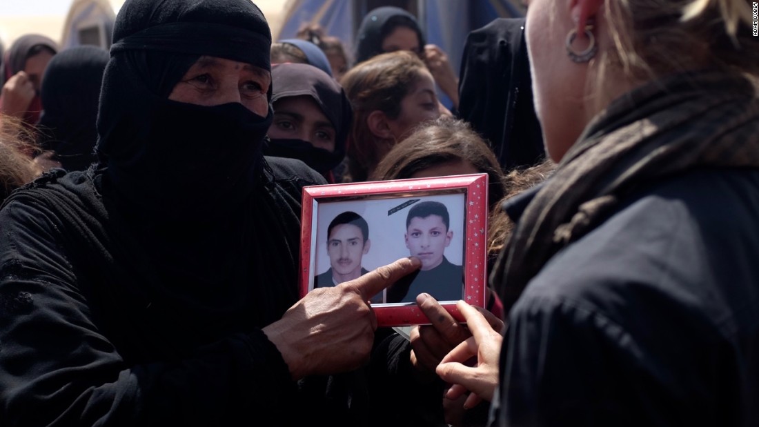 Iraqi mother Piswa Treish holds a picture of her son (right) who was killed by ISIS.