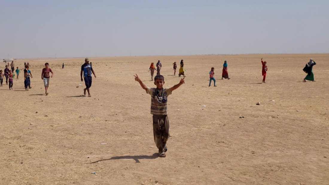 Refugee camps outside al-Qayyara, Iraq, where people live in hostile conditions, with scorching desert winds and constant heat.