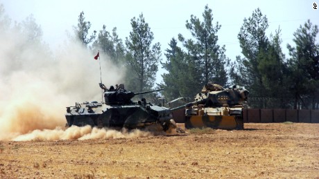A Turkish army tank and an armored vehicle are in Karkamis, near the Syrian border, on Tuesday.