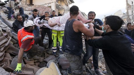 A woman is pulled from the rubble following an earthquake in Amatrice, Italy.